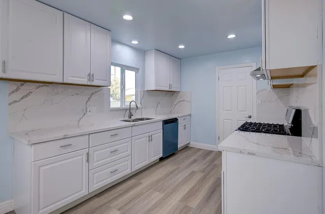 a kitchen with granite countertop white cabinets and white appliances
