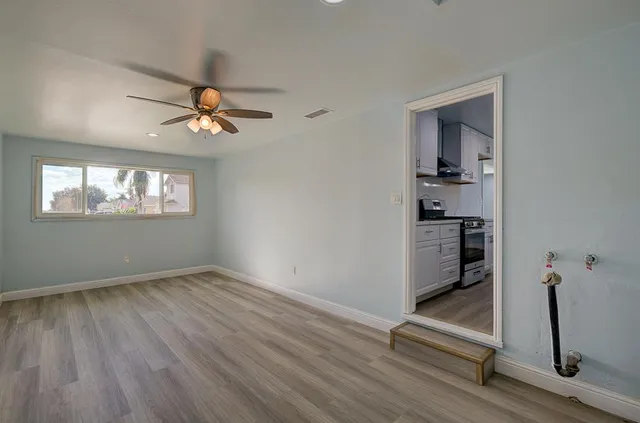 a kitchen with stainless steel appliances granite countertop a sink a stove and a wooden floors