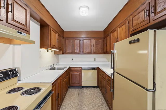 a kitchen with a sink a refrigerator and cabinets