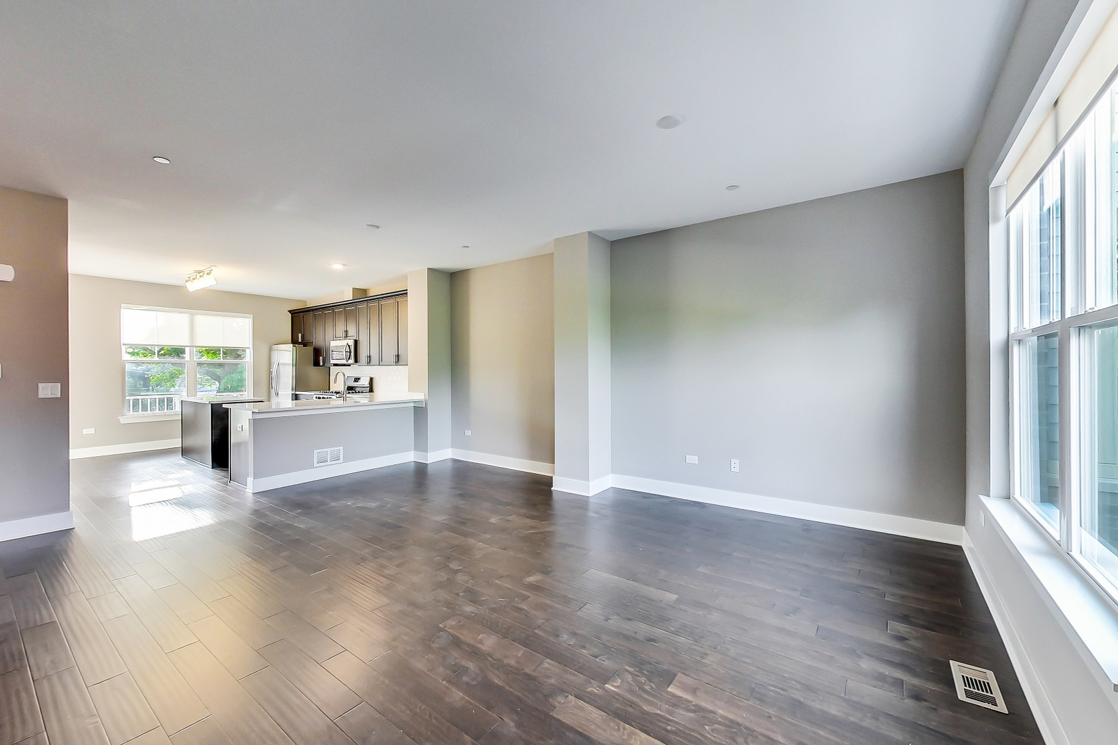 25 Clay Avenue, Unit E Highwood, IL 60040 - Photo 17 of 29 a view of a kitchen and an empty room with wooden floor and a kitchen