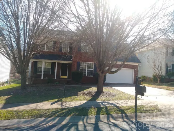 a front view of a house with yard yard and tree
