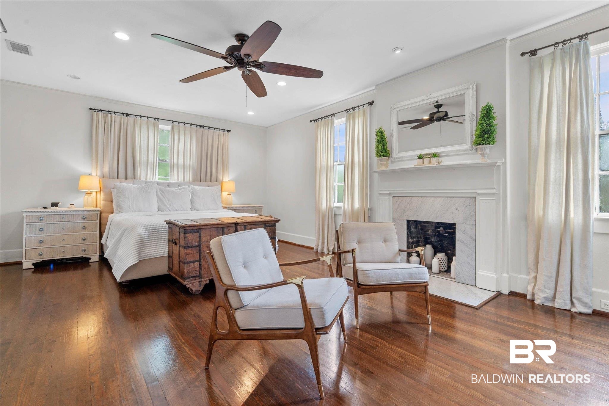 3863 Old Shell Road Mobile, AL 36608 - Photo 26 of 48 Spacious room featuring rich wood-finish flooring, a ceiling fan, recessed lighting, and a prominent fireplace with a marble surround and white mantel