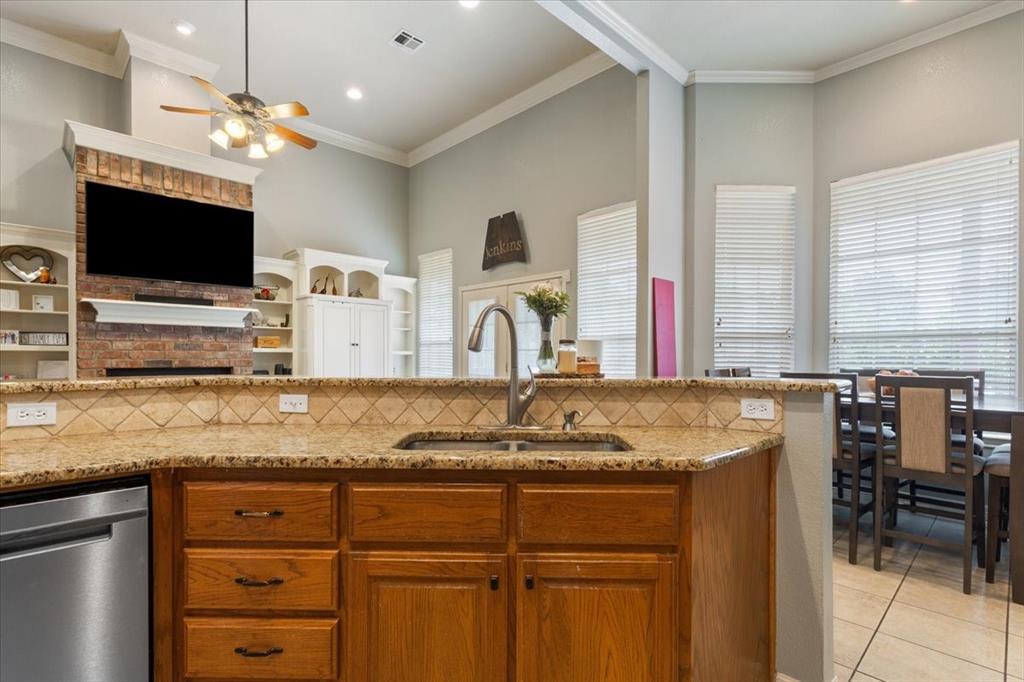 5616 Landsdown Drive Waco, TX 76708 - Photo 13 of 33 Kitchen island with a granite countertop, undermount sink, and wood cabinetry
