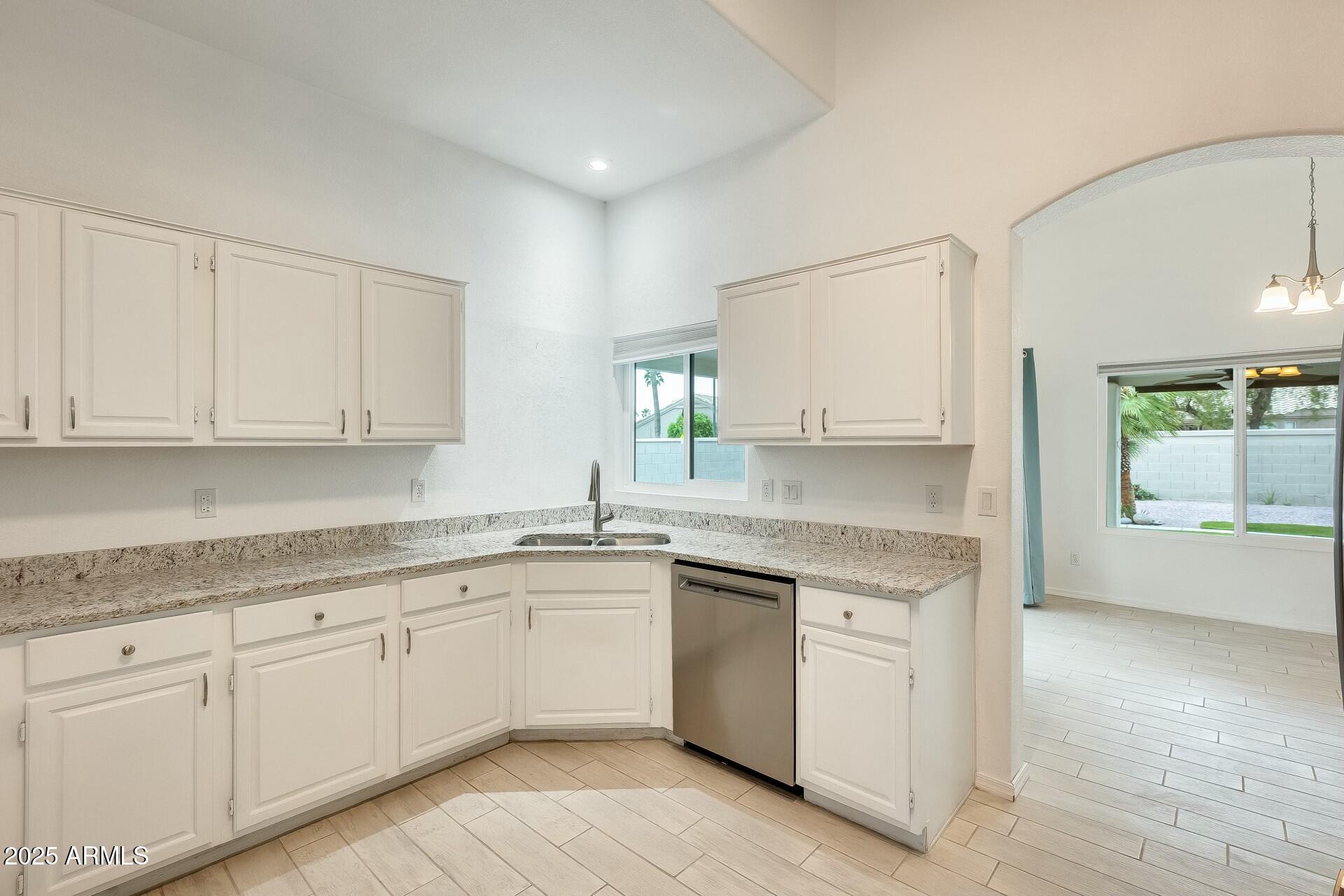 17514 North Rainbow Circle Surprise, AZ 85374 - Photo 16 of 69 a kitchen with white cabinets appliances a sink and a window