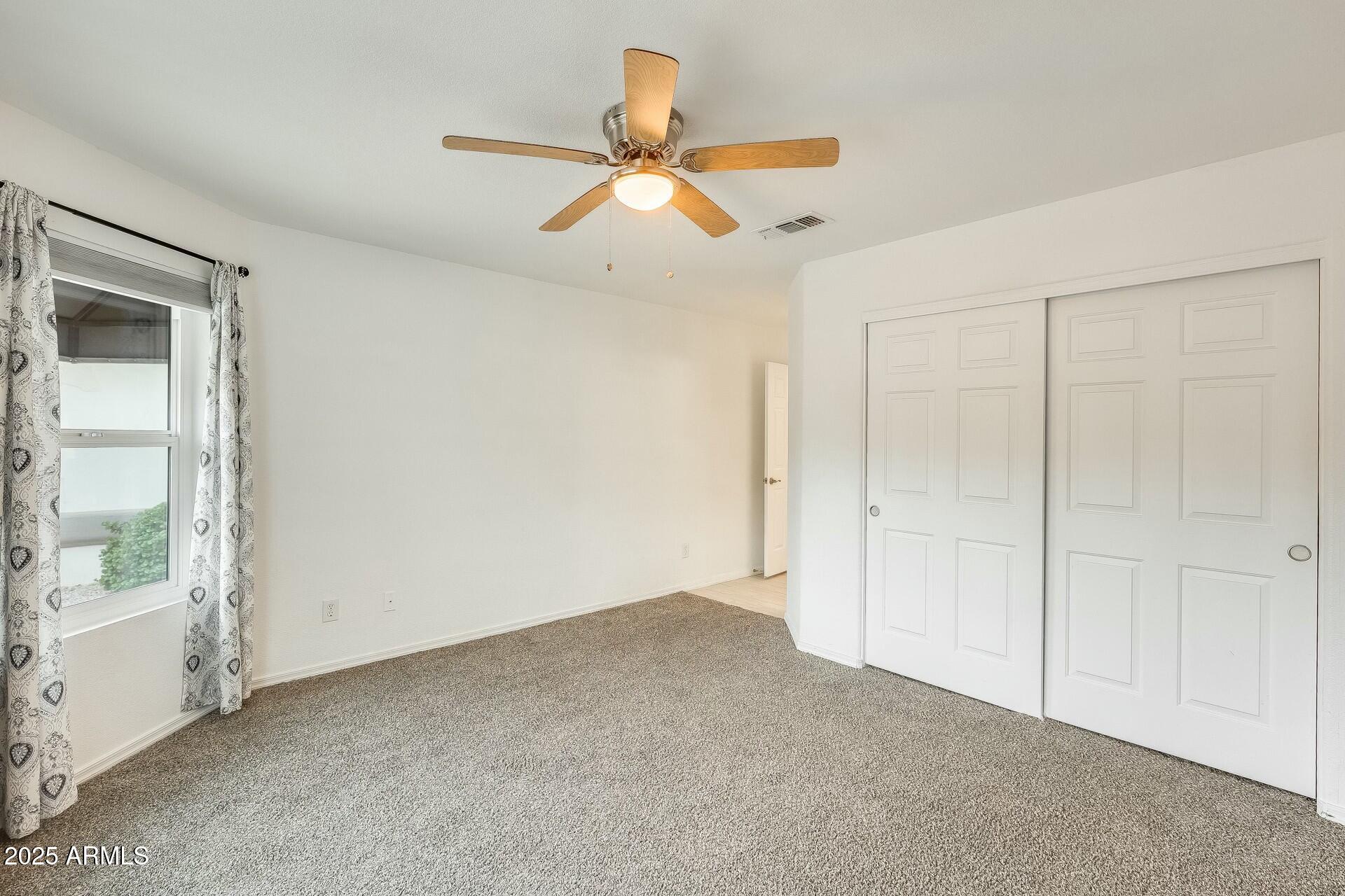 17514 North Rainbow Circle Surprise, AZ 85374 - Photo 24 of 69 an empty room with windows and fan