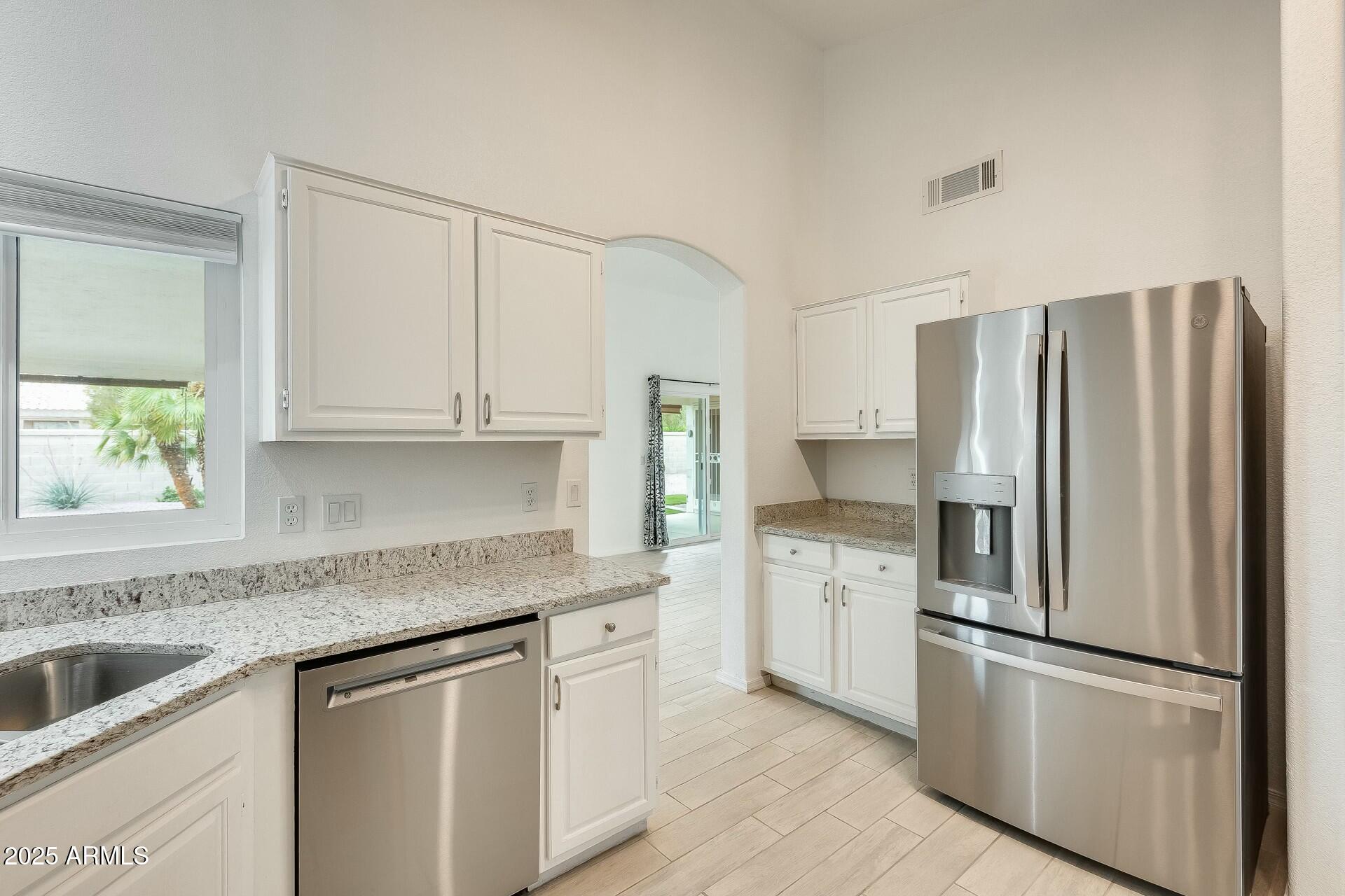 17514 North Rainbow Circle Surprise, AZ 85374 - Photo 4 of 69 a kitchen with stainless steel appliances granite countertop a refrigerator sink and white cabinets