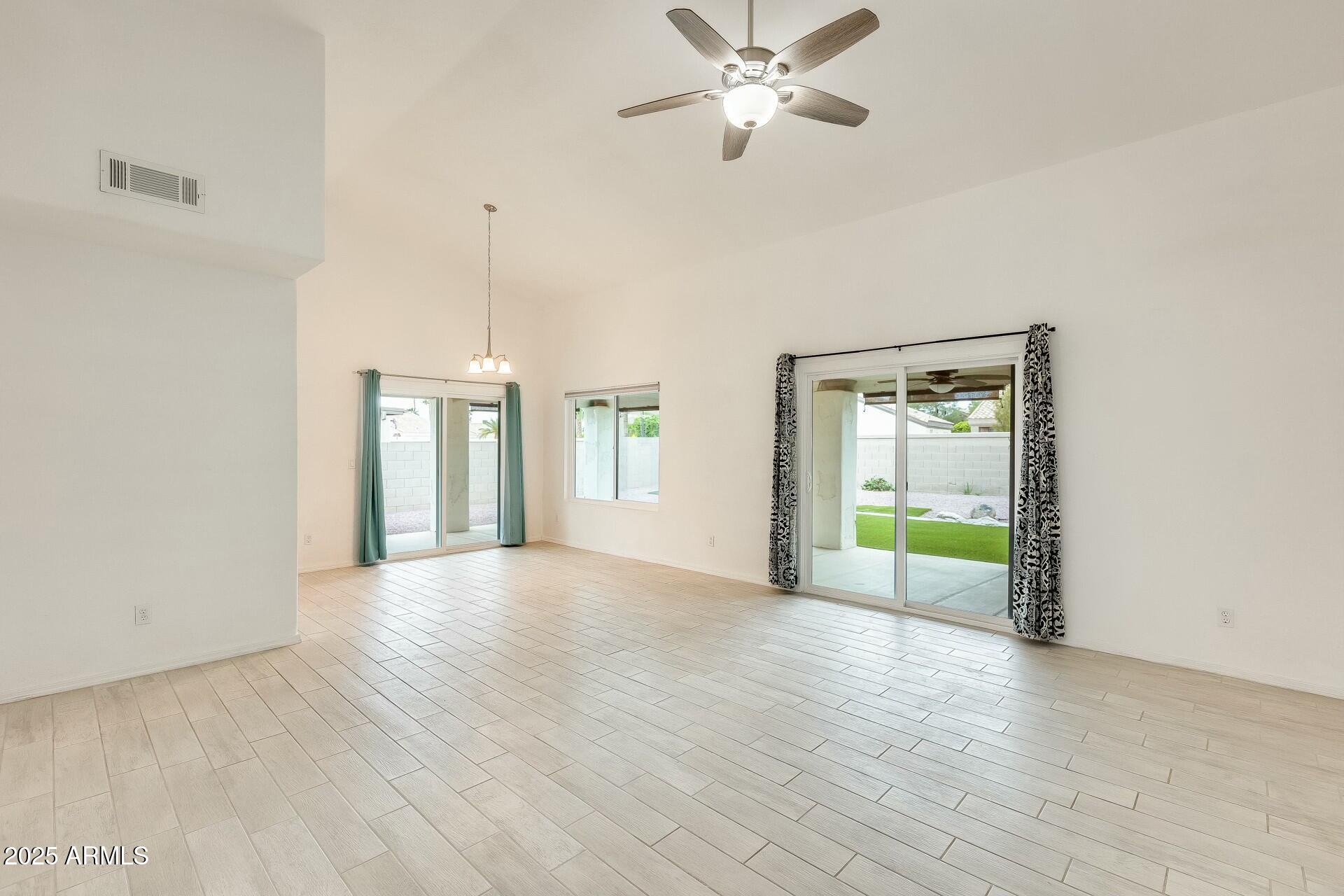 17514 North Rainbow Circle Surprise, AZ 85374 - Photo 9 of 69 a view of an empty room with a window and wooden floor