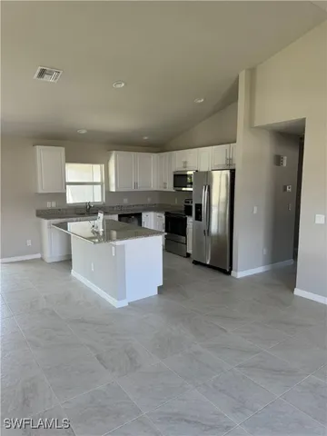 a large kitchen with stainless steel appliances lots of counter top space