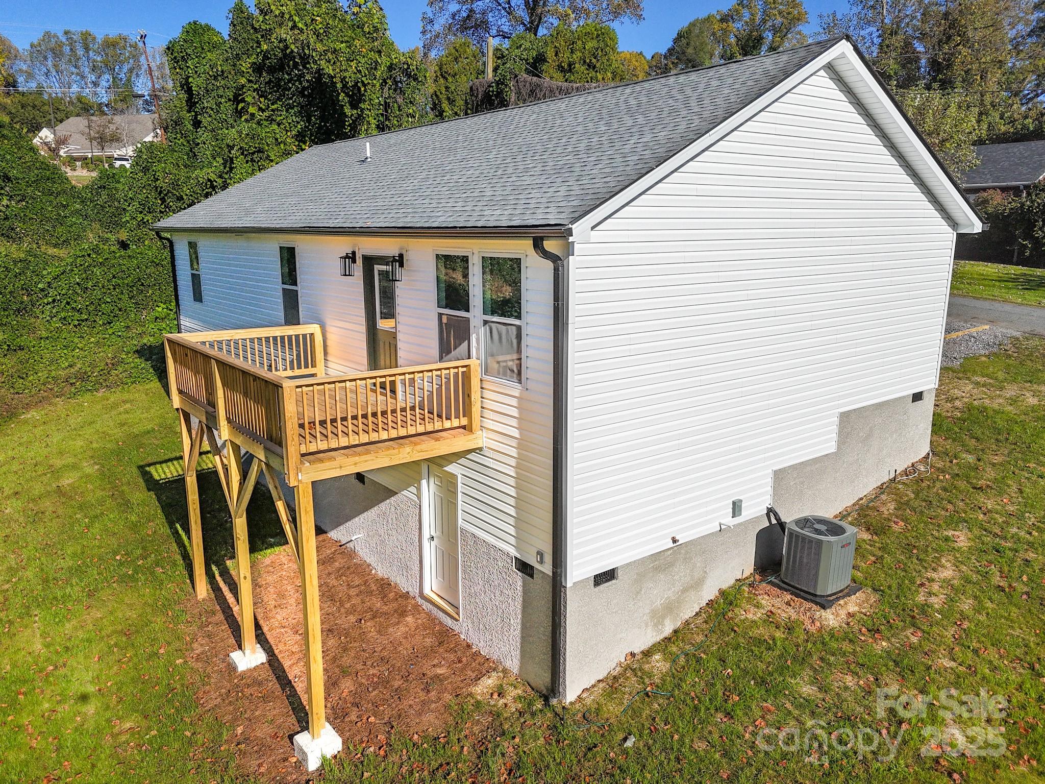 22 Hoyle Street Marion, NC 28752 - Photo 4 of 43 a view of a white house with a small yard and potted plants