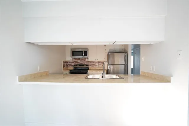 a view of kitchen with wooden cabinet and refrigerator