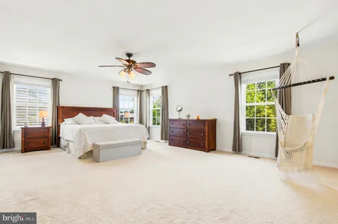 a spacious bedroom with a bed dresser and a window