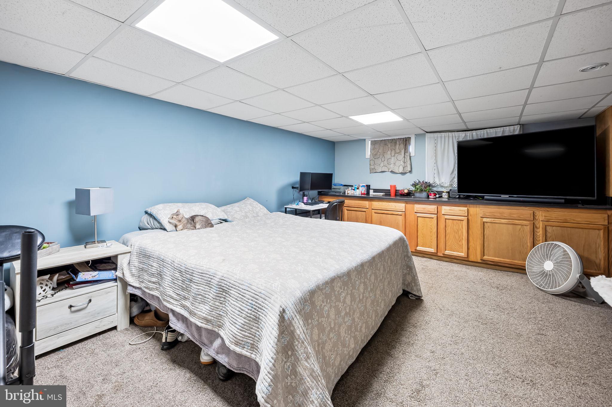 229 Arden Road West Baltimore, MD 21225 - Photo 16 of 17 a spacious bedroom with a bed and a flat screen tv