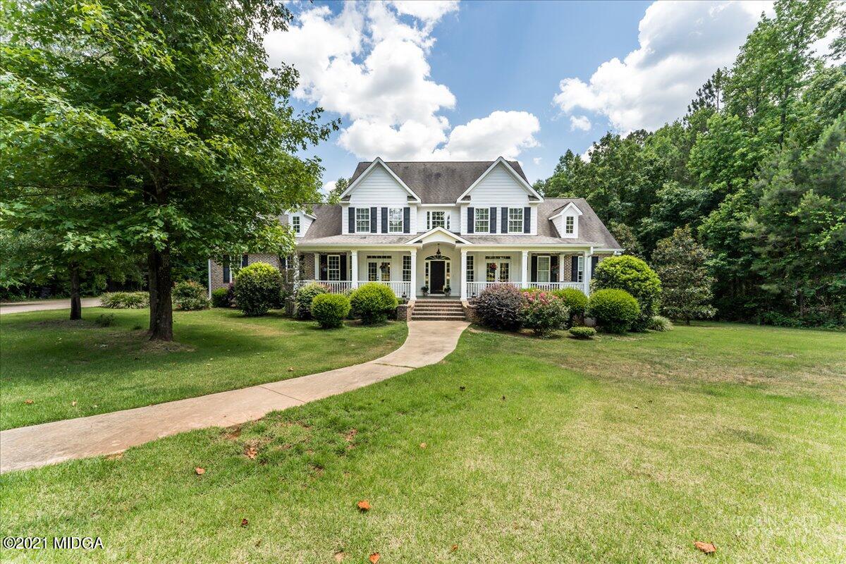 908 Jenkins Road Forsyth, GA 31029 - Photo 1 of 34 a front view of a house with garden and trees