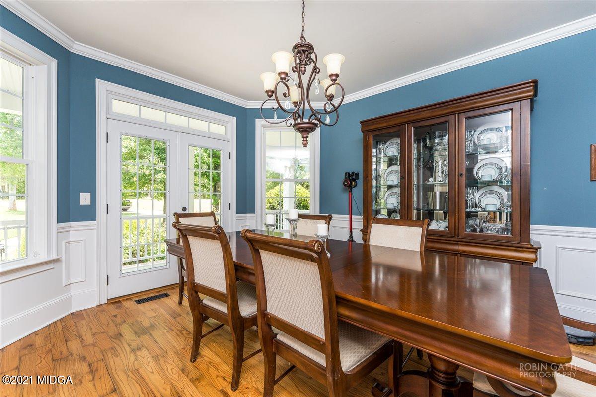 908 Jenkins Road Forsyth, GA 31029 - Photo 7 of 34 a view of a dining room with furniture a chandelier and wooden floor