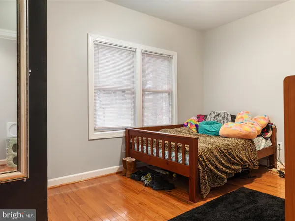 a bedroom with a bed rug and wooden floor
