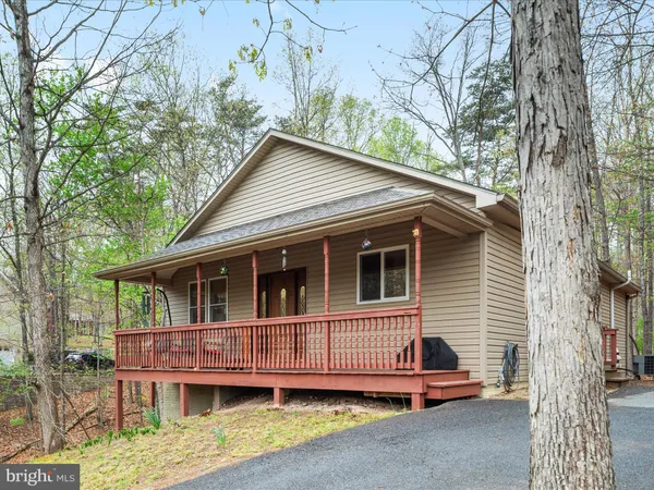 a view of a house with a yard and large trees