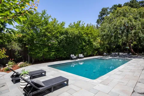 a view of a backyard with swimming pool