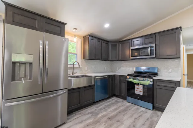 a kitchen with stainless steel appliances granite countertop a refrigerator microwave and sink