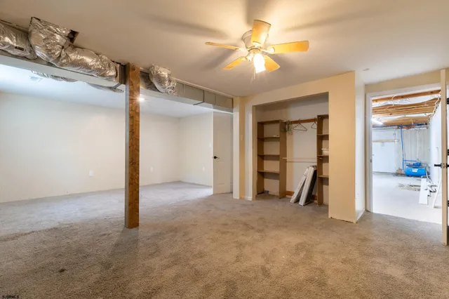 an empty room with closet and a chandelier fan