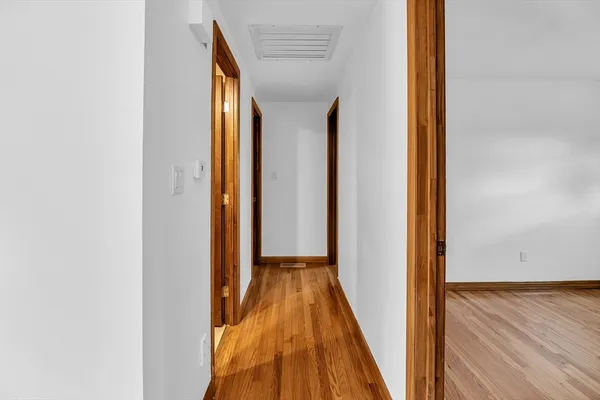a view of a hallway with wooden floor and closet