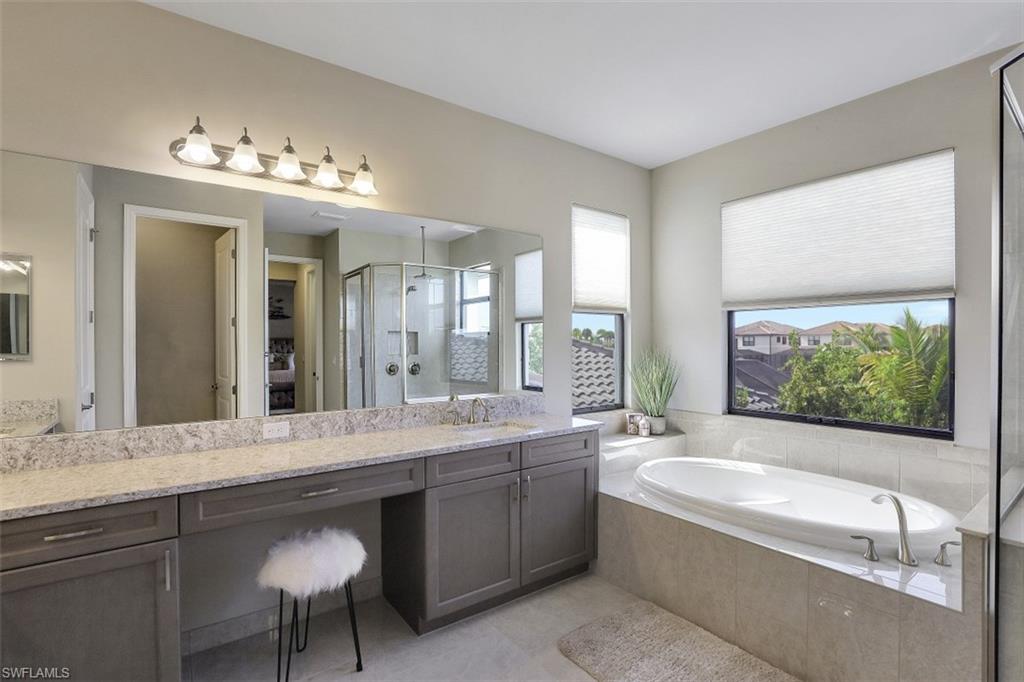 4334 Aurora Street Naples, FL 34119 - Photo 14 of 31 a bathroom with a large tub sink and mirror