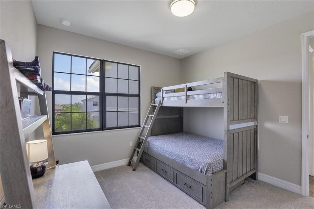 4334 Aurora Street Naples, FL 34119 - Photo 15 of 31 a bedroom with a bed and wooden floor