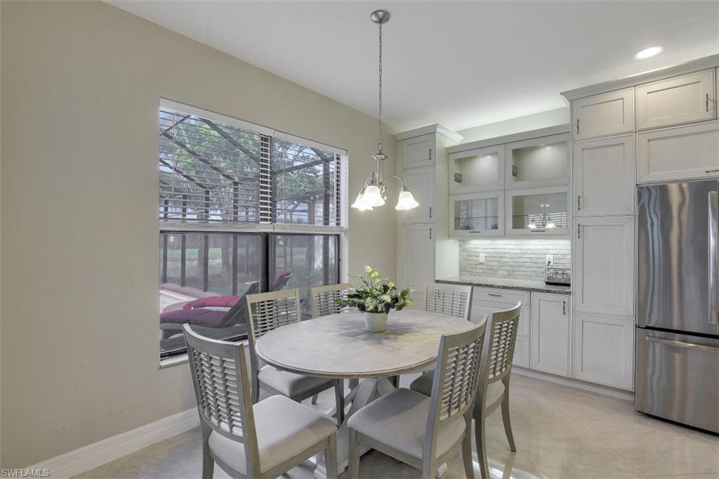 4334 Aurora Street Naples, FL 34119 - Photo 7 of 31 a view of a dining room with furniture and a chandelier
