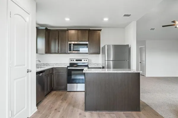 a large kitchen with a refrigerator and a stove top oven