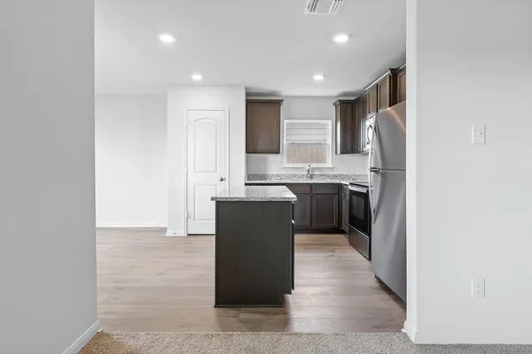 a kitchen with stainless steel appliances granite countertop a sink a stove and a refrigerator
