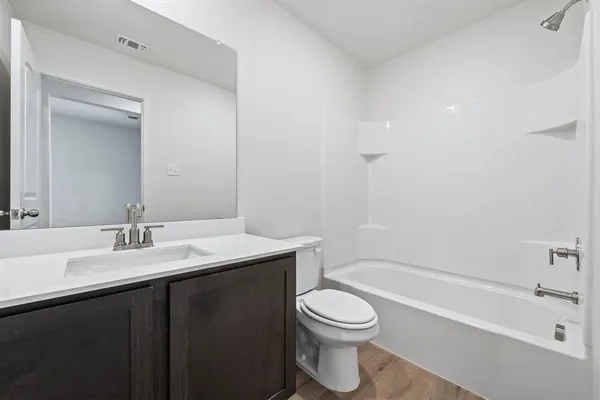 a bathroom with a bathtub a sink a toilet and a mirror