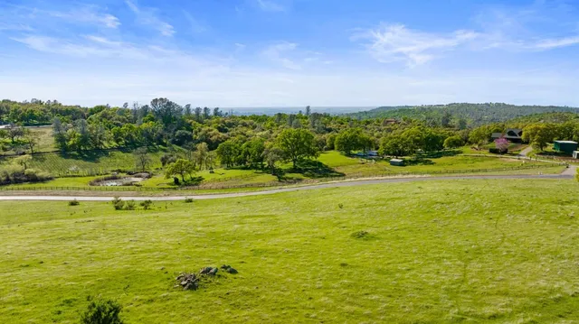 a view of a large yard with lawn chairs