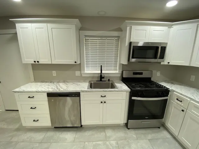 a kitchen with stainless steel appliances granite countertop a sink and a stove