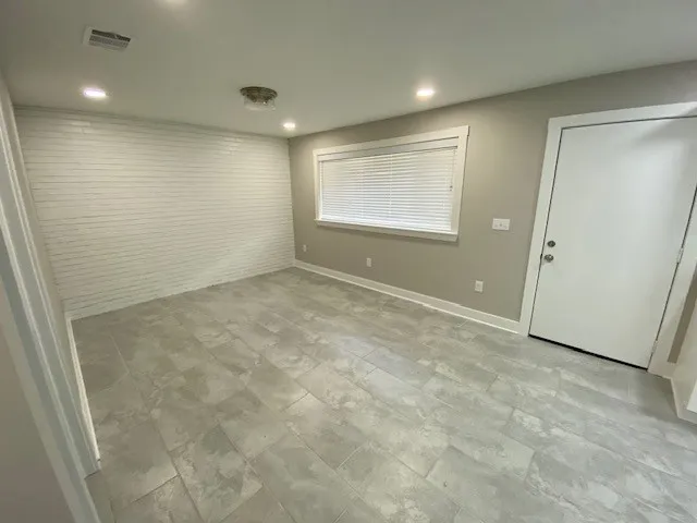 an empty room with windows & cabinet