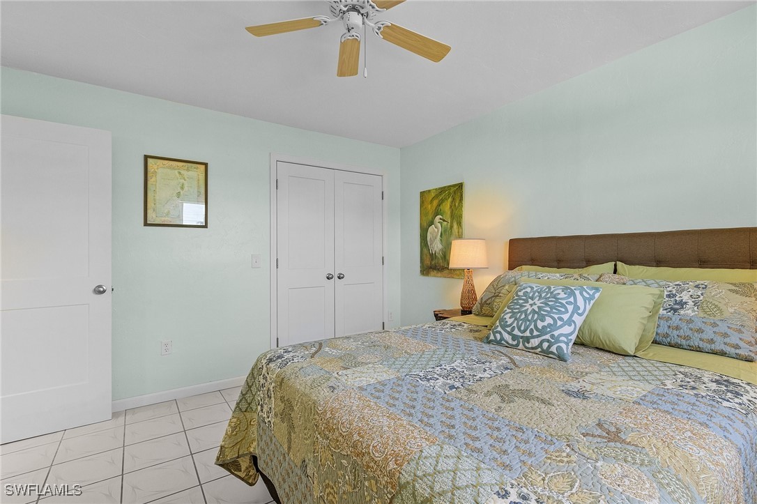 3201-3203 Stabile Road St. James City, FL 33956 - Photo 13 of 34 a bedroom with a bed and a ceiling fan