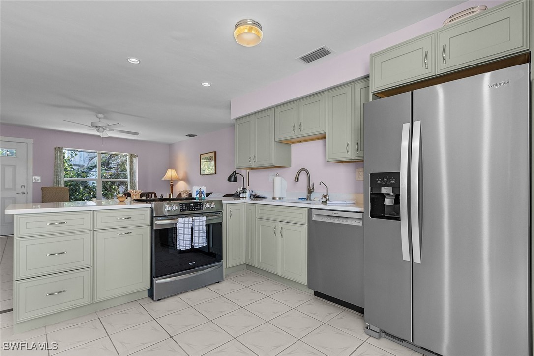 3201-3203 Stabile Road St. James City, FL 33956 - Photo 21 of 34 a kitchen with white cabinets and stainless steel appliances