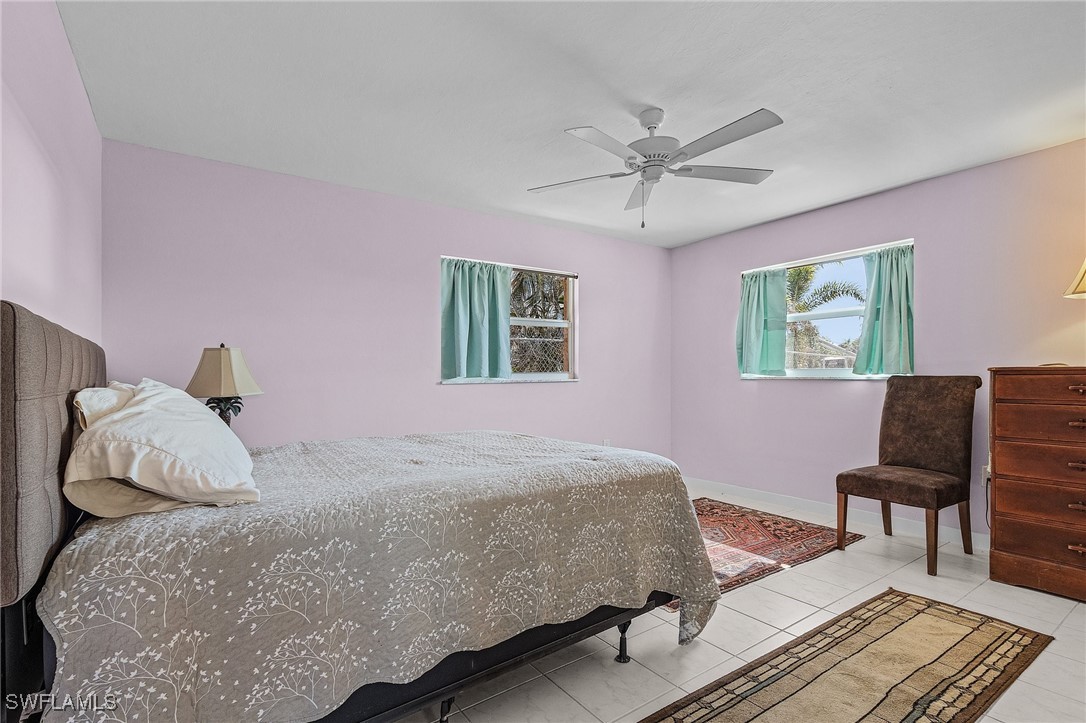 3201-3203 Stabile Road St. James City, FL 33956 - Photo 24 of 34 a bedroom with a bed dresser and a window