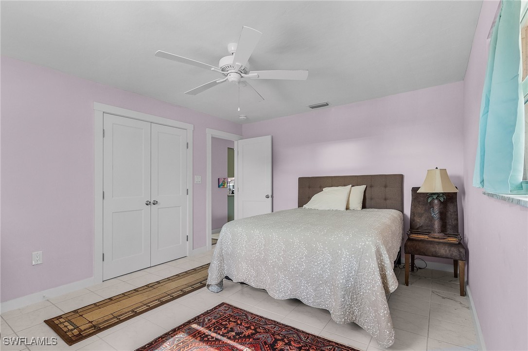 3201-3203 Stabile Road St. James City, FL 33956 - Photo 25 of 34 a bedroom with a bed and a chandelier