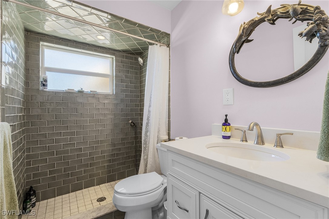 3201-3203 Stabile Road St. James City, FL 33956 - Photo 28 of 34 a bathroom with a sink a toilet and a mirror