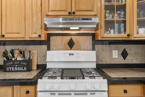 a stove top oven sitting inside of a kitchen