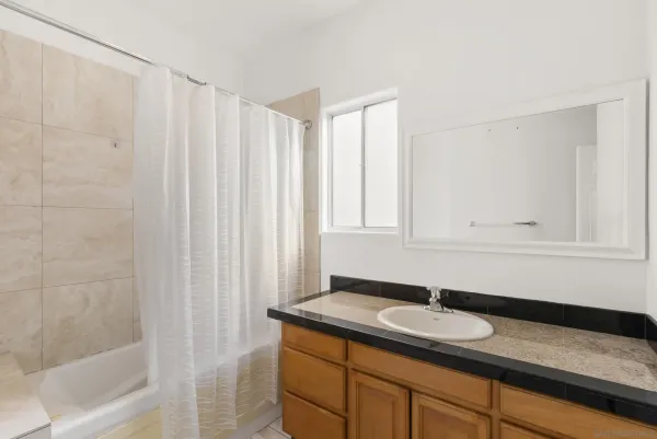 a bathroom with a granite countertop sink and a mirror
