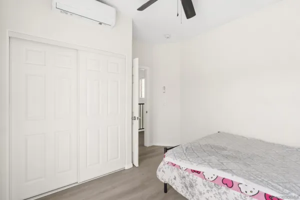 a bedroom with a bed and wooden floor