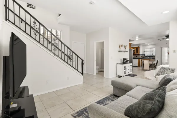 a living room with furniture and kitchen view with wooden floor