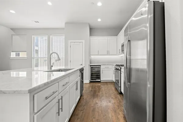 a kitchen with refrigerator cabinets and wooden floor
