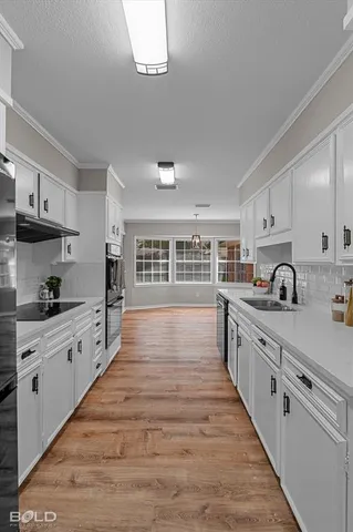 a large kitchen with stainless steel appliances granite countertop a lot of counter space and wooden floors