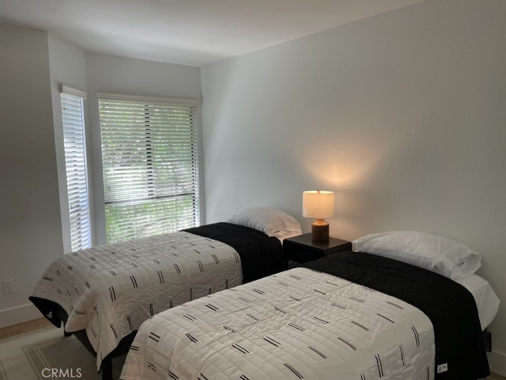 27793 Rota, Unit 14 Mission Viejo, CA 92692 - Photo 15 of 18 a bedroom with two beds and a lamp next to a window