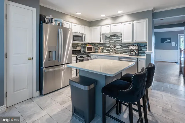 a kitchen with stainless steel appliances a refrigerator and a table