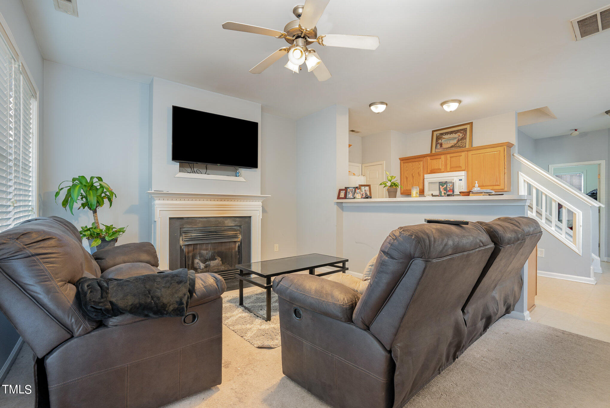 5828 Wynmore Road Raleigh, NC 27610 - Photo 6 of 19 a living room with furniture fireplace and a flat screen tv