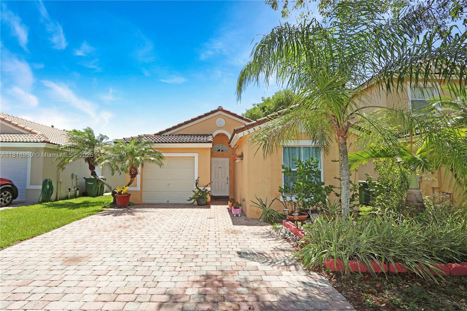 1585 Southeast 20th Road Homestead, FL 33035 - Photo 16 of 26 a front view of a house with a yard and potted plants