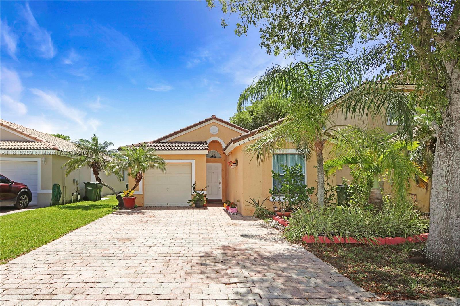 1585 Southeast 20th Road Homestead, FL 33035 - Photo 17 of 26 a front view of a house with a yard and potted plants