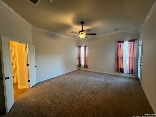 an empty room with windows and fan chandelier